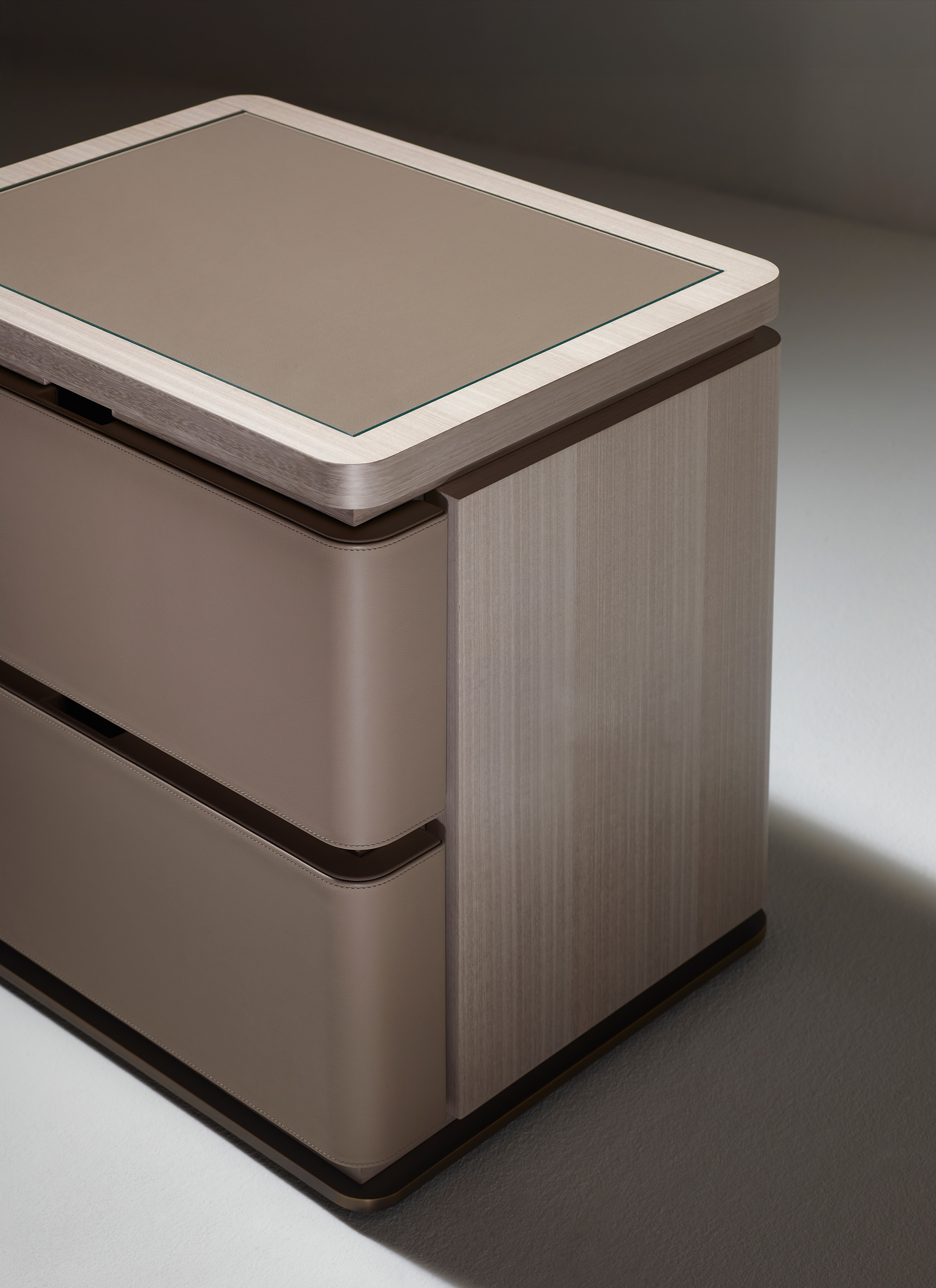 Au Bout de la Nuit is a wooden bedside table with drawers, bronze base and top covered in leather with glass, from Promemoria's Amaranthine Tales collection | Promemoria