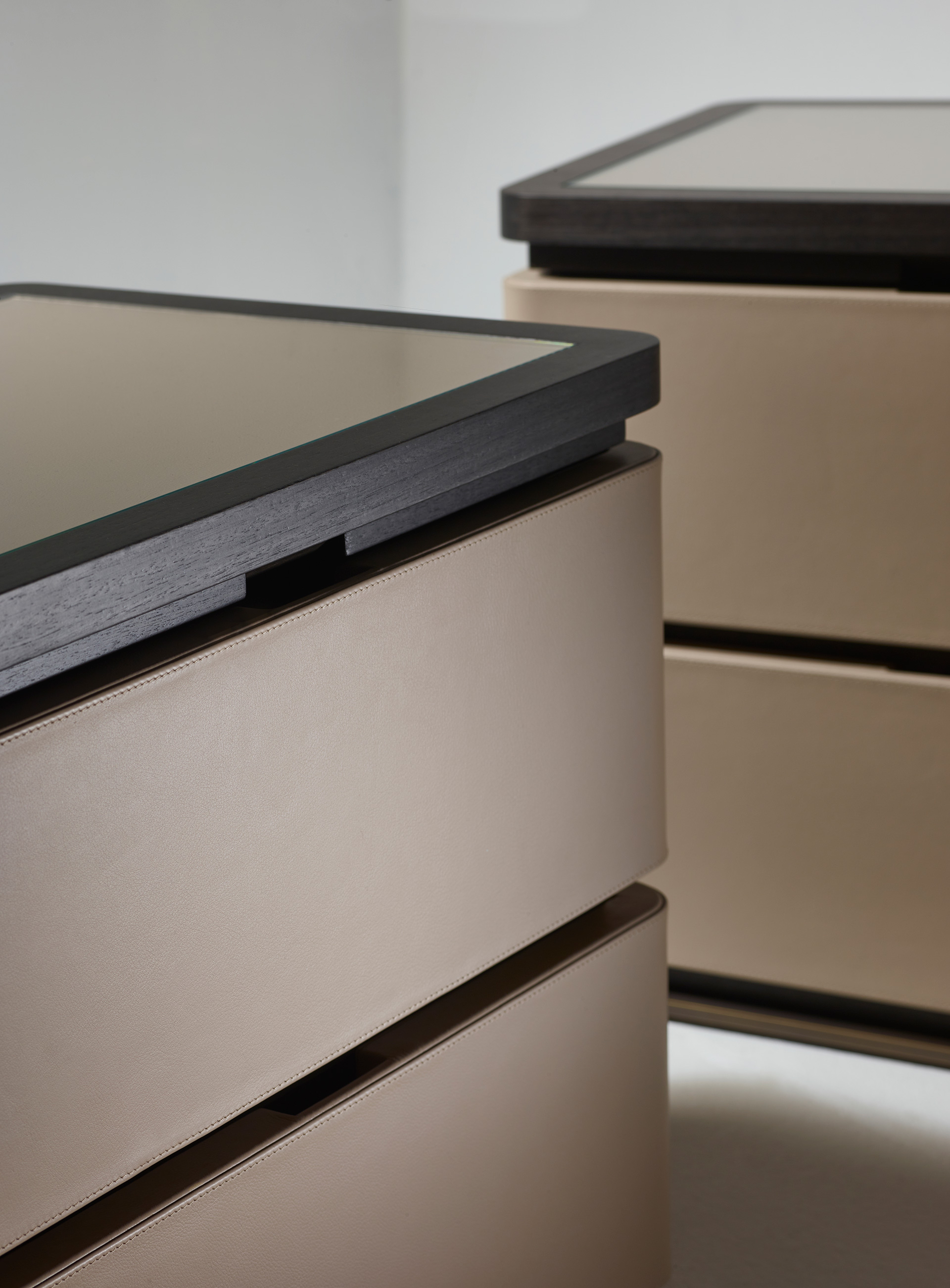 Au Bout de la Nuit is a wooden bedside table with drawers, bronze base and top covered in leather with glass, from Promemoria's Amaranthine Tales collection | Promemoria