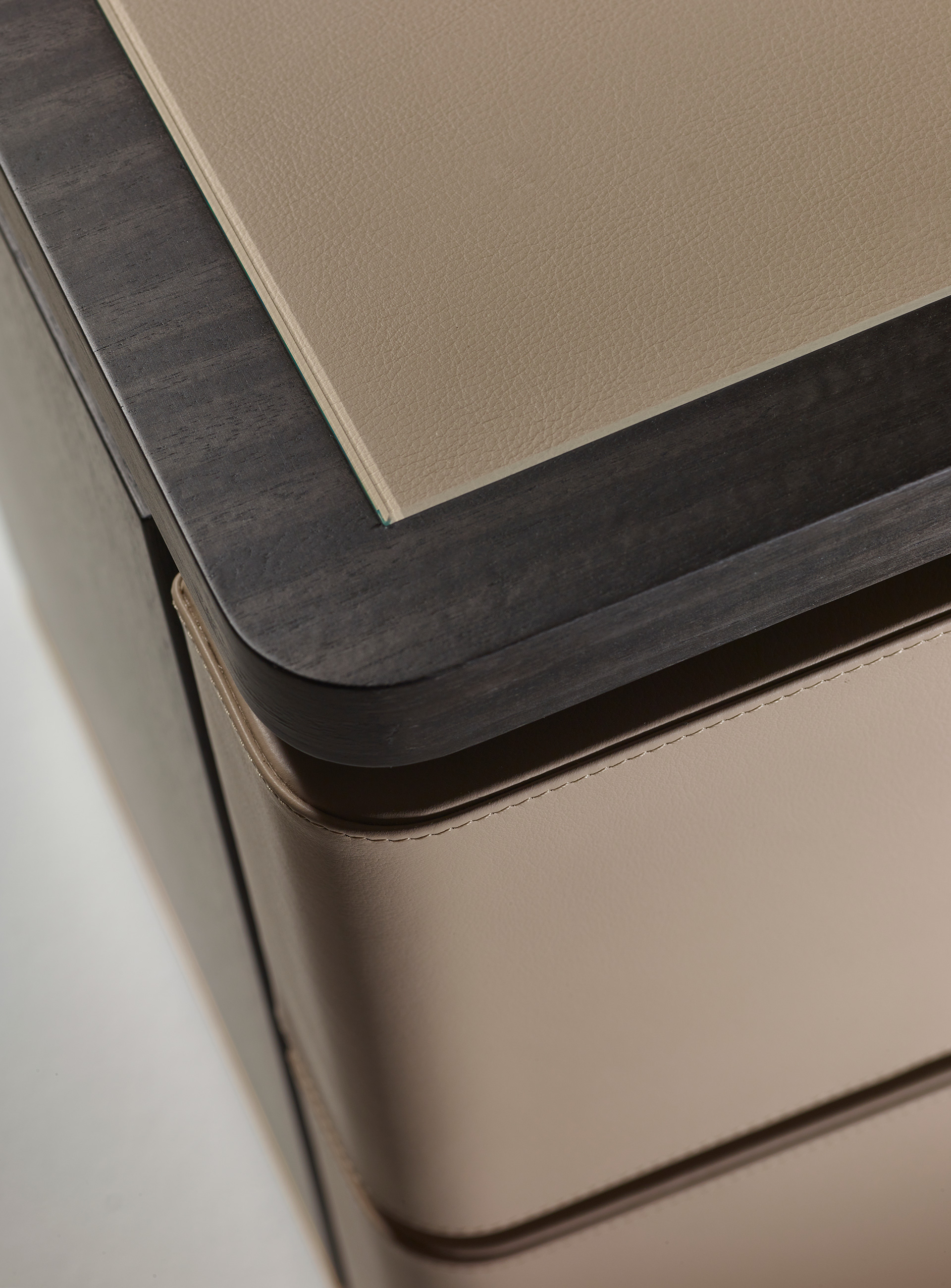 Au Bout de la Nuit is a wooden bedside table with drawers, bronze base and top covered in leather with glass, from Promemoria's Amaranthine Tales collection | Promemoria