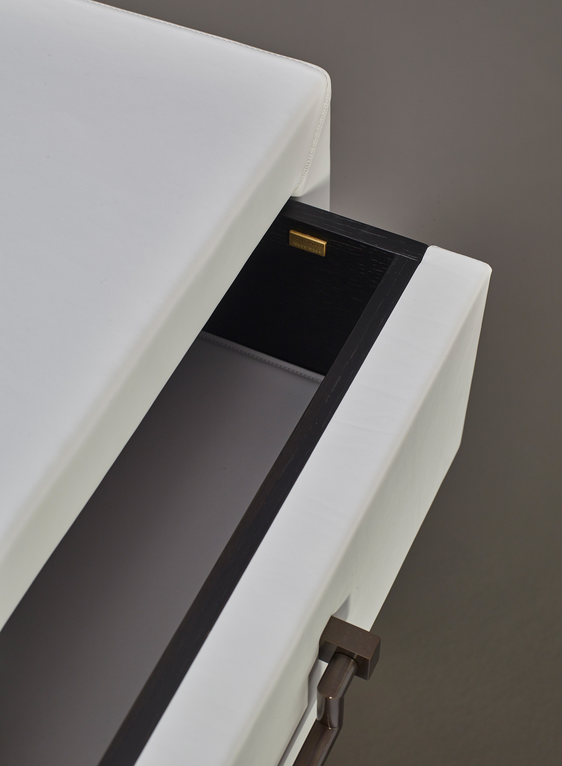 Drawer detail of Future, a wooden chest of drawers covered in leather or fabric with leather placemats and handles in leather or bronze, nickel and chrome from Promemoria's catalogue | Promemoria