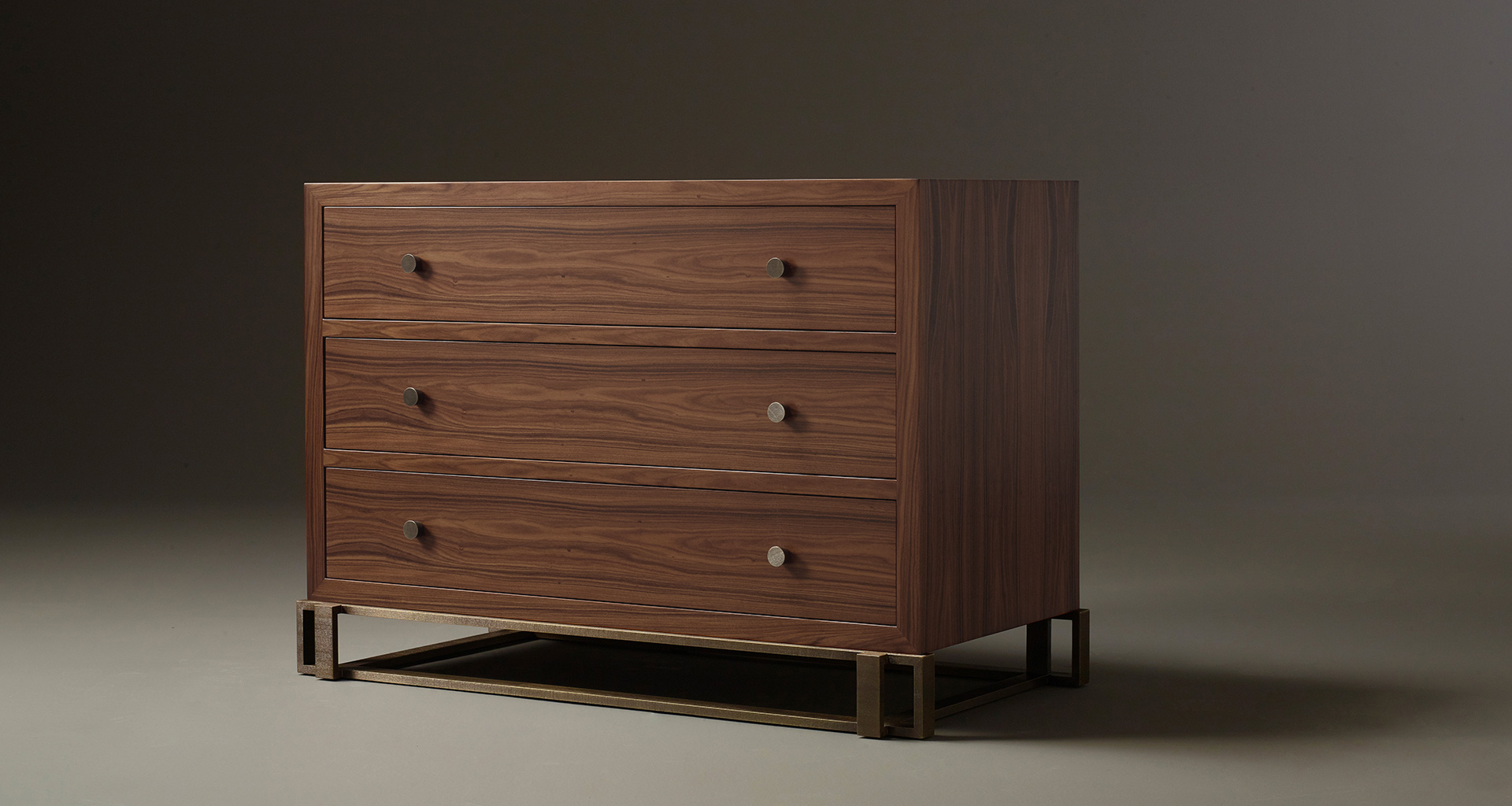 Margot is a wooden chest of drawers with metal details and bronze base and knobs from Promemoria's catalogue | Promemoria
