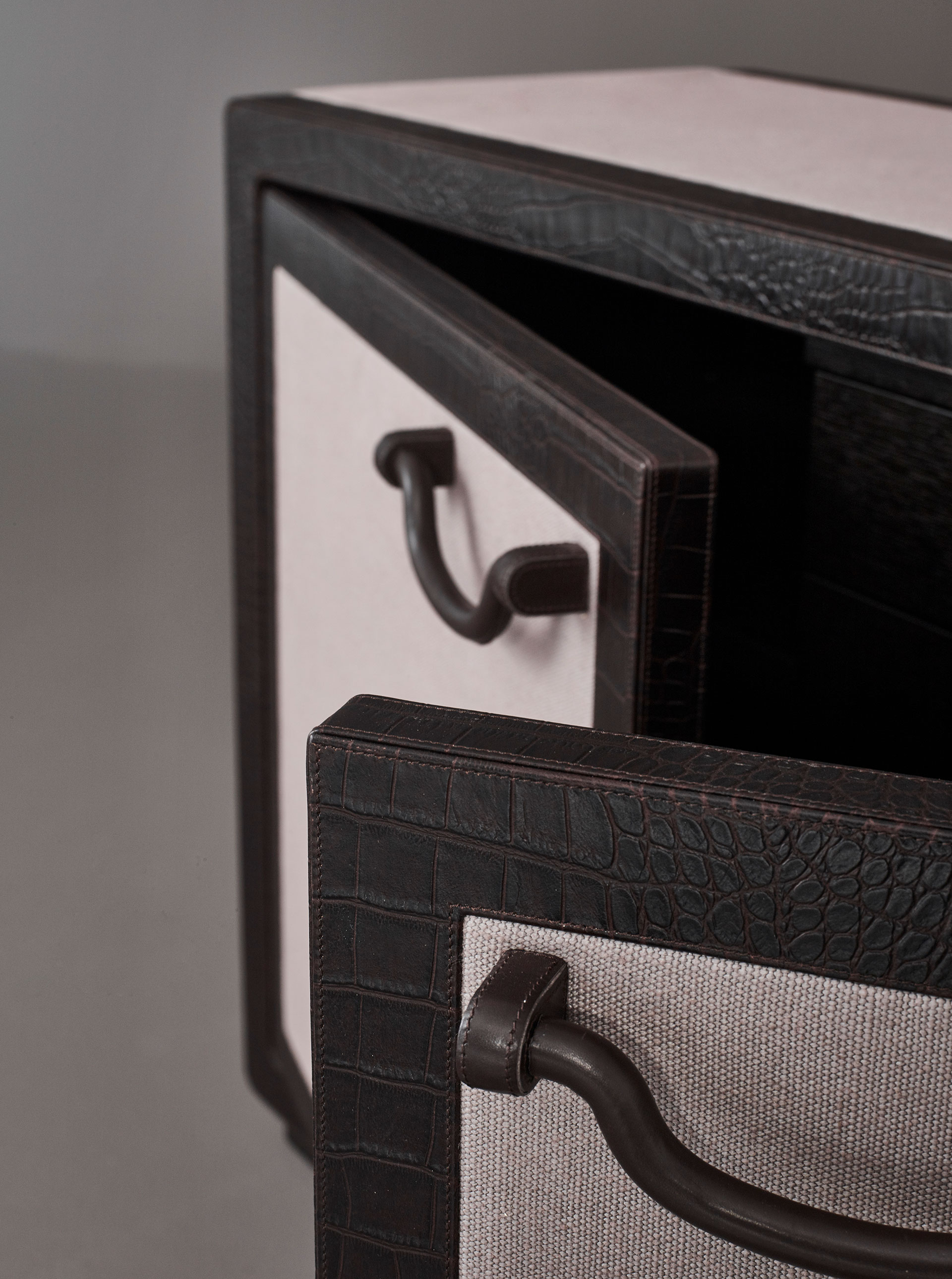Leather handle detail of Future Voyager Atto II, a wooden cabinet covered in leather and fabric with handles and placemats in leather from Promemoria's catalogue | Promemoria