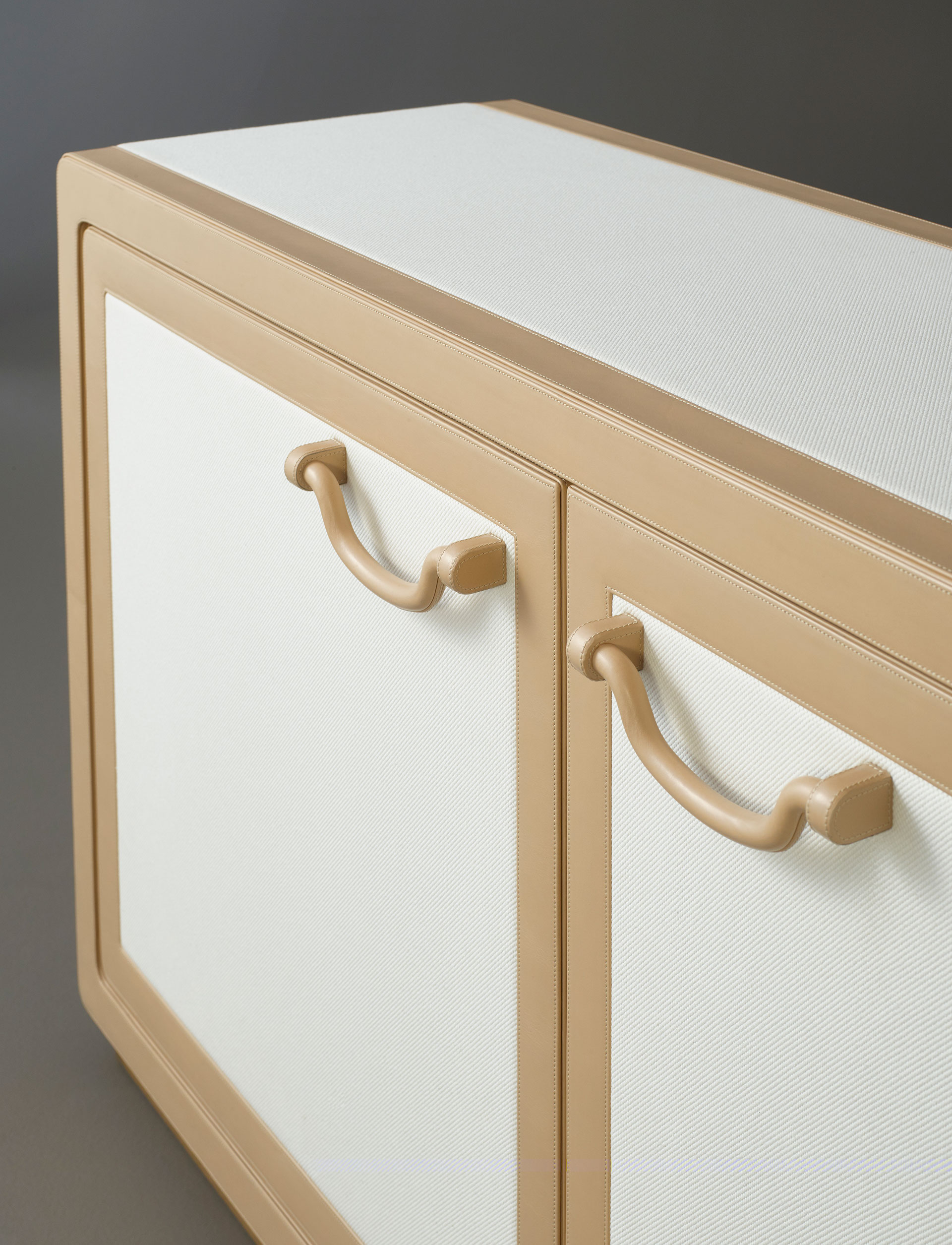 Future Voyager Atto II is a wooden cabinet covered in leather and fabric with handles and placemats in leather from Promemoria's catalogue | Promemoria