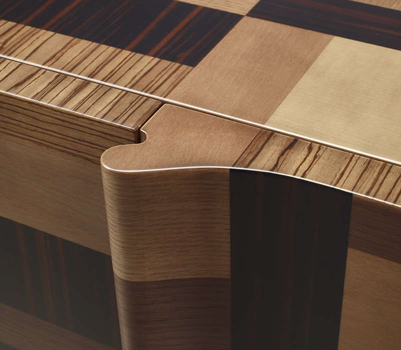 Handle detail of Oleandra, a wooden cabinet that can have a geometric patchwork design with light and dark woods interweaved and bronze details from Promemoria's catalogue | Promemoria