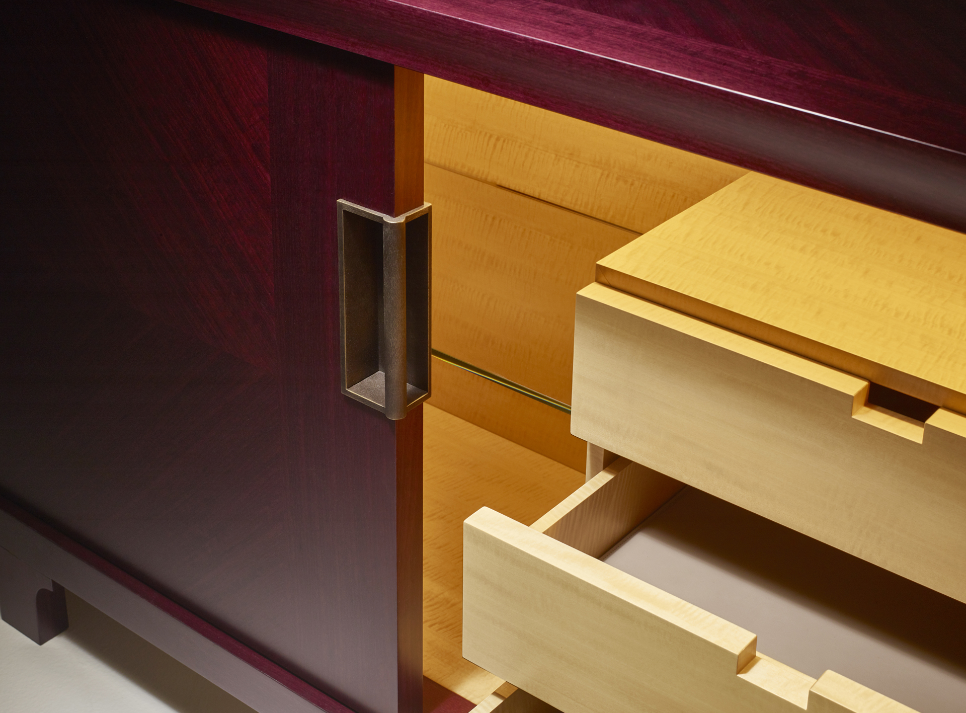 Interno di Oolong, mobile contenitore basso in legno con ante scorrevoli, frontali dei ripiani e cassetti in pelle e maniglie in bronzo, del catalogo di Promemoria | Promemoria