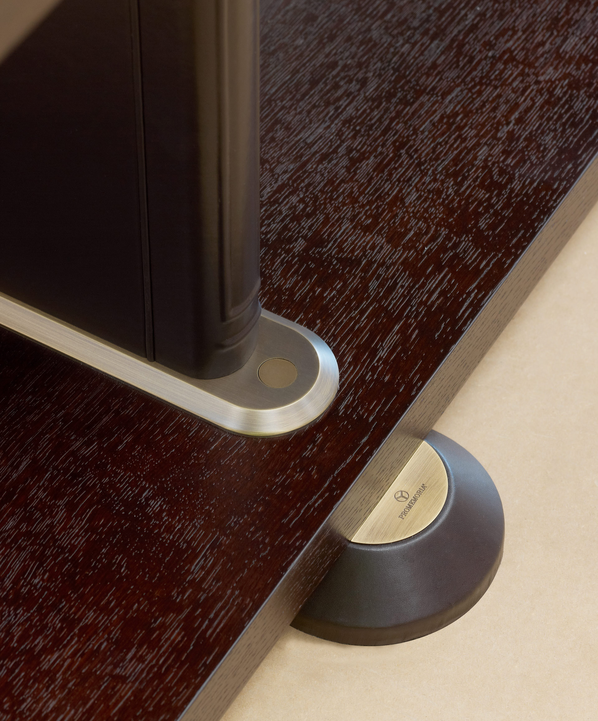 Detail of Peggy, a modular wooden bookcase with leather covered supports and bronze details, from Promemoria's catalogue | Promemoria