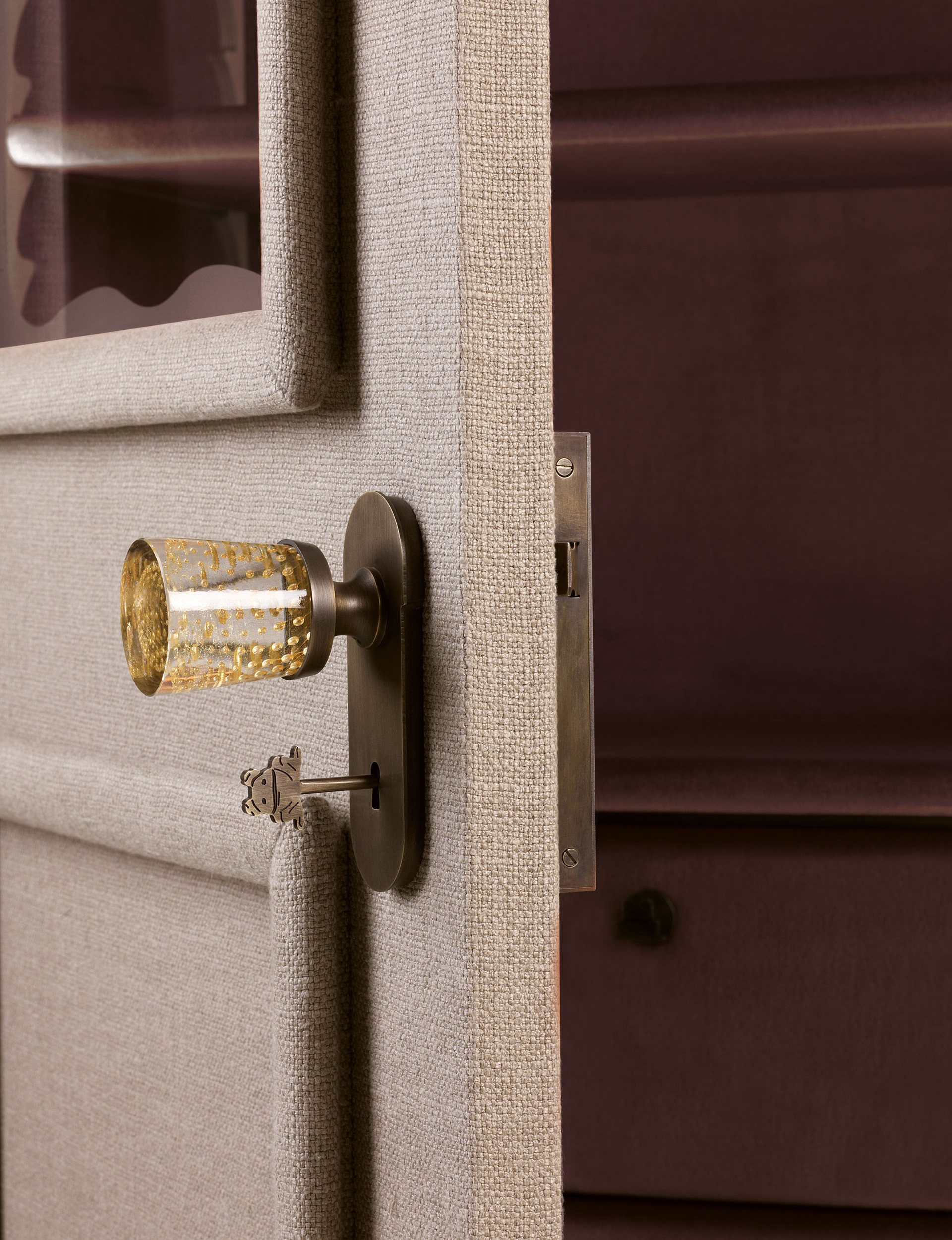 Handle detail of George, a wooden modular wardrobe with two, three or four doors covered in velvet or linen and details in bronze, from the Promemoria's catalogue | Promemoria