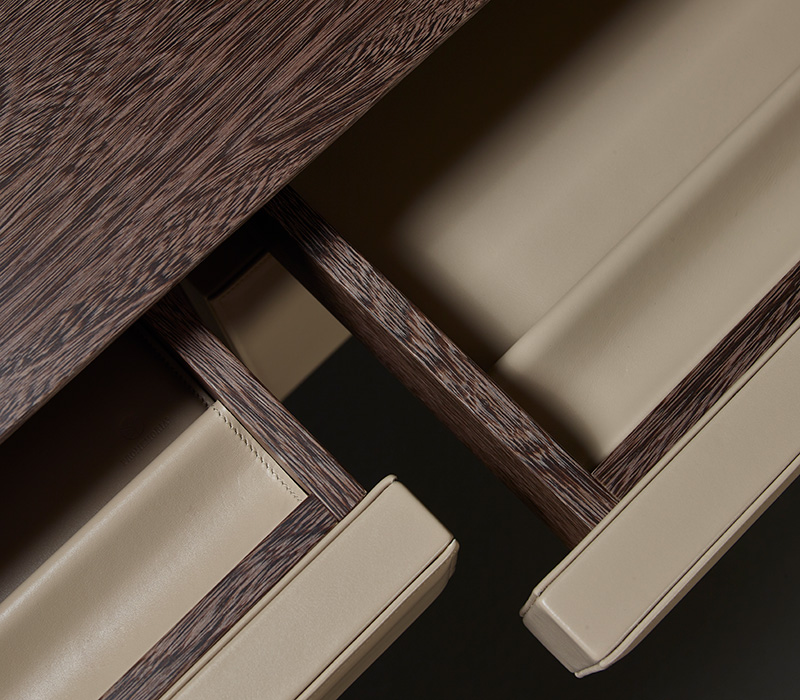 Detail of Theo, a wooden writing desk that can be covered in leather with leather details or with bronze details from the Promemoria's catalogue | Promemoria