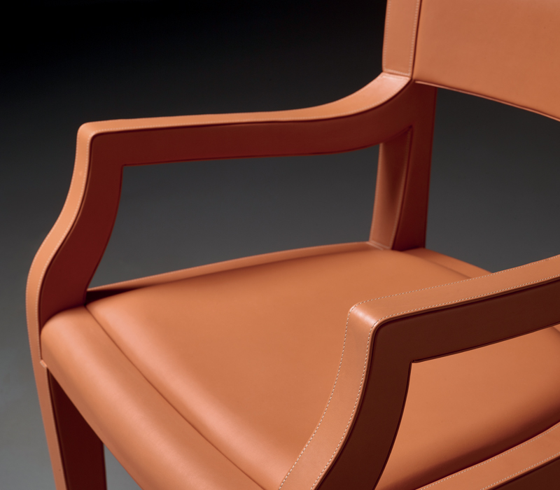 Détail du dossier bas d’Eloise, chaise de salle à manger en bois avec assise en cuir, proposée avec ou sans accoudoirs. Ce meuble figure dans le catalogue Promemoria | Promemoria