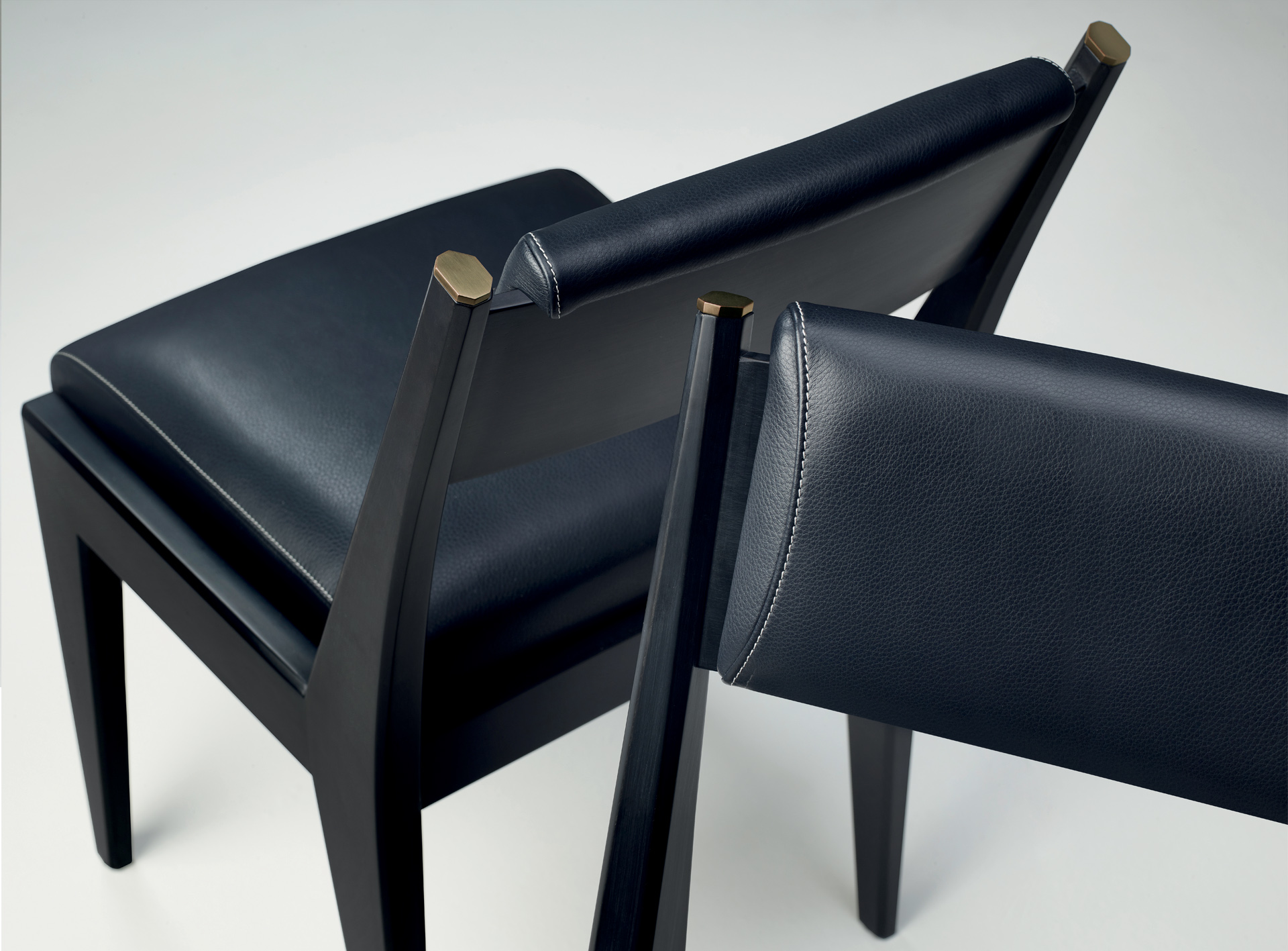 Iris is a wooden chair with bronze details and leather cushions, from Promemoria's Indigo Tales | Promemoria