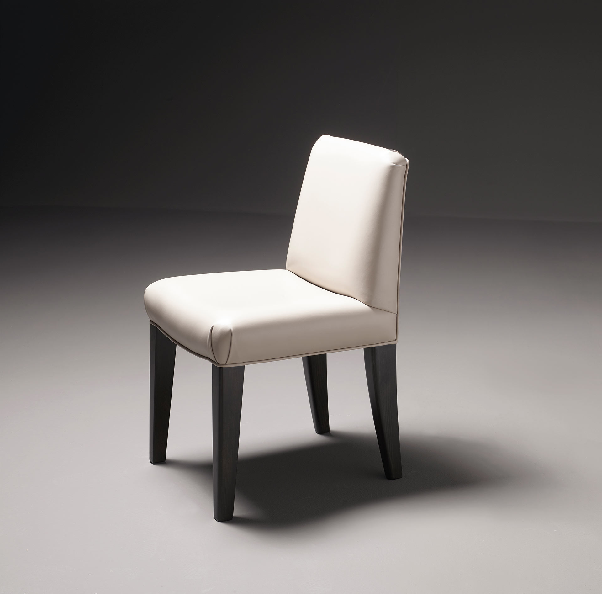 Detail of Isotta, a wooden dining chair with or without armrests and with a fabric or leather covered back, from Promemoria's catalogue | Promemoria