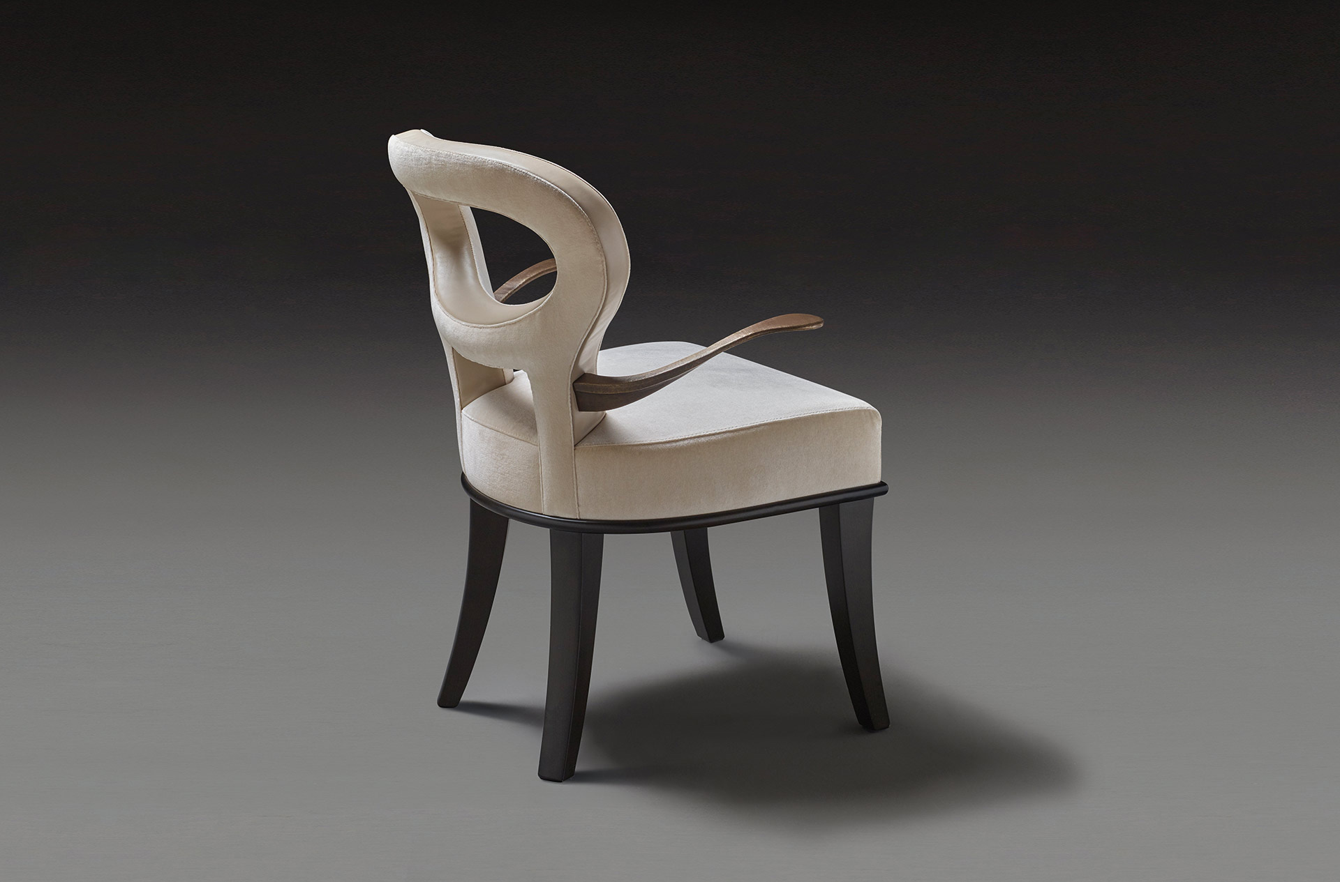 Detail of Roka, wooden chair covered in fabric and leather, with or without bronze armrests, from Promemoria's catalogue | Promemoria