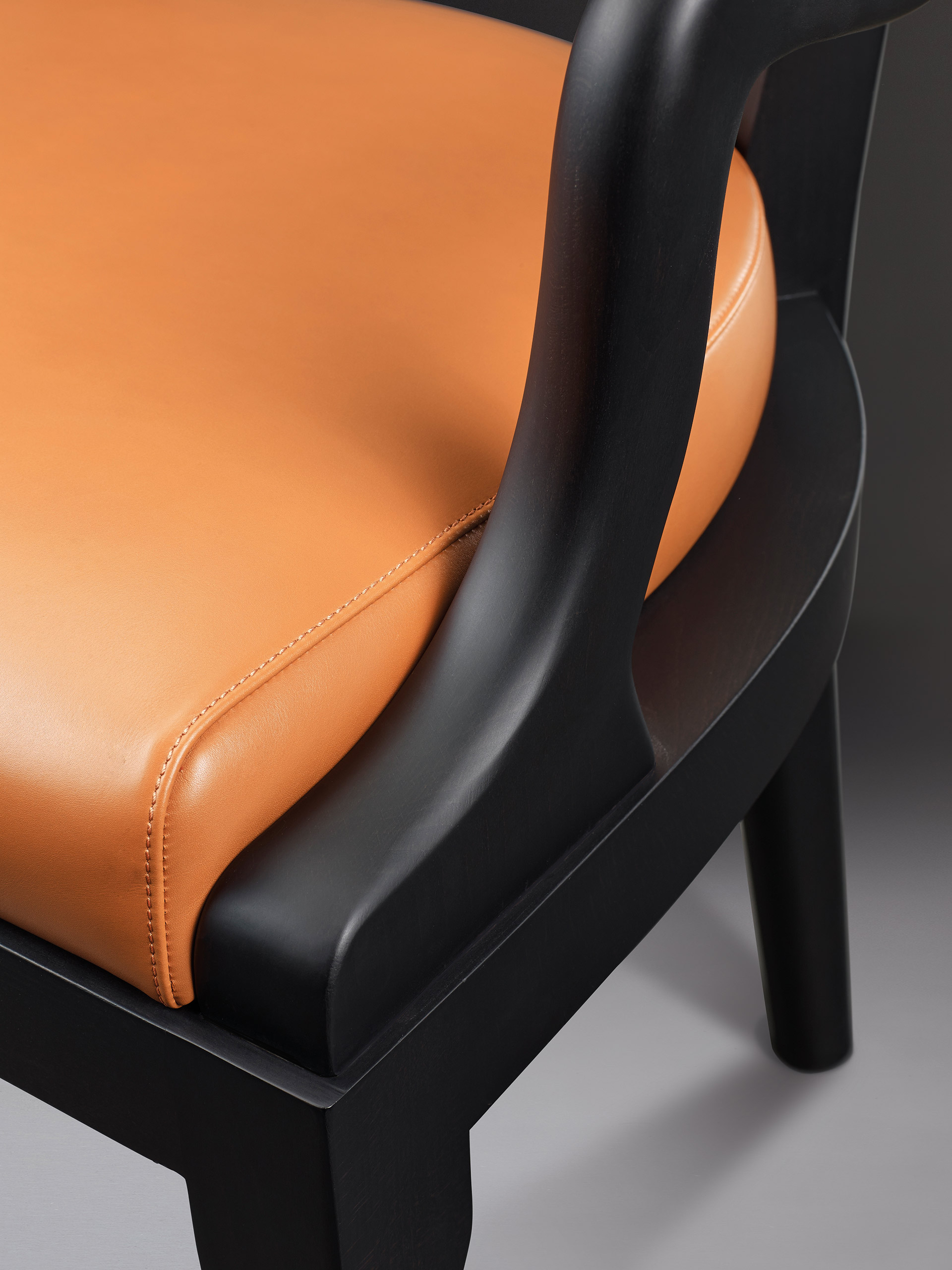 Detail of Sofia, a wooden dining chair with fabric or leather seat and with armrests, from Promemoria's catalogue | Promemoria