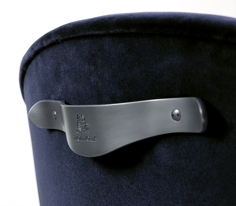 Detal of Vittoria, an office chair with a metal or bronze base, covered in fabric or leather with a bronze handle on the back, from Promemoria's catalogue | Promemoria