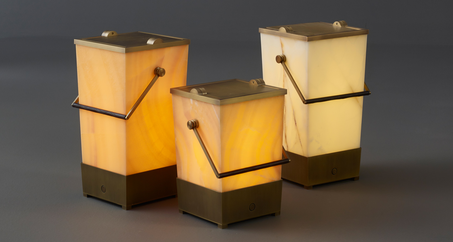 Hara è una lampada da terra a LED senza fili, a forma di secchiello con un manico in bronzo rivestito in pelle, del catalogo di Promemoria | Promemoria