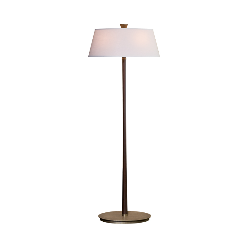 Rita est un lampadaire LED avec un pied en bois, un piètement-socle en bronze et un abat-jour en lin, coton ou soie avec bordure cousue main. Ce luminaire figure dans le catalogue Promemoria | Promemoria