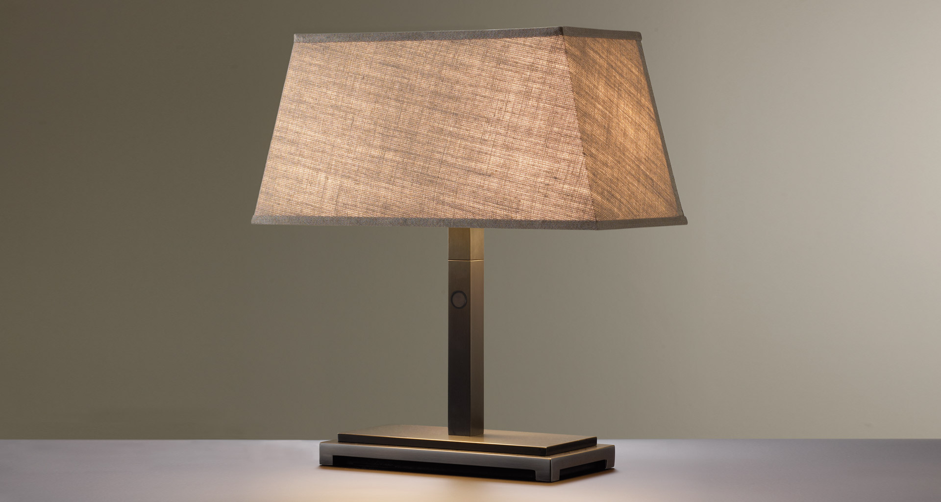 Warry Bronzo è una lampada da tavolo a LED con struttura in bronzo e paralume in lino, cotone o seta bordata a mano, del catalogo di Promemoria | Promemoria