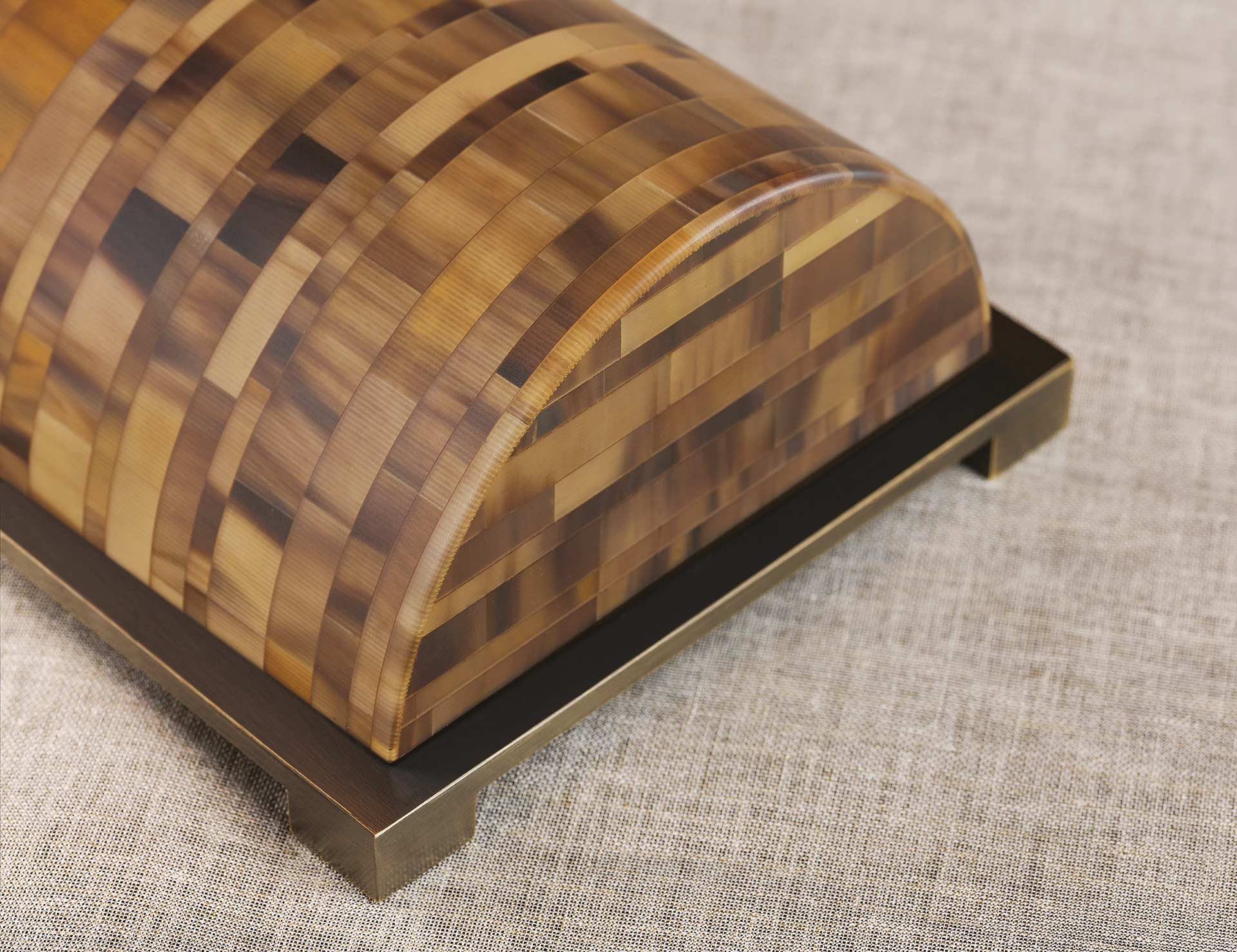 Dettaglio della base di Zebù, lampada da tavolo a LED con struttura in corno, base e dettagli in bronzo e paralume in lino, cottone o seta, del catalogo di Promemoria | Promemoria