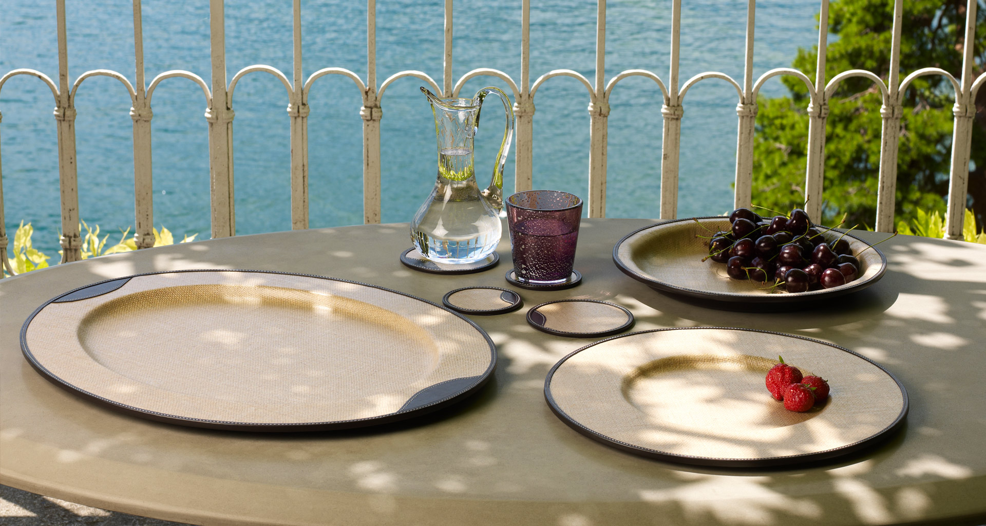 Saturno è un set da tavola in juta gommata e pelle, che lo rendono idrorepellente e resistente, del catalogo di Promemoria | Promemoria