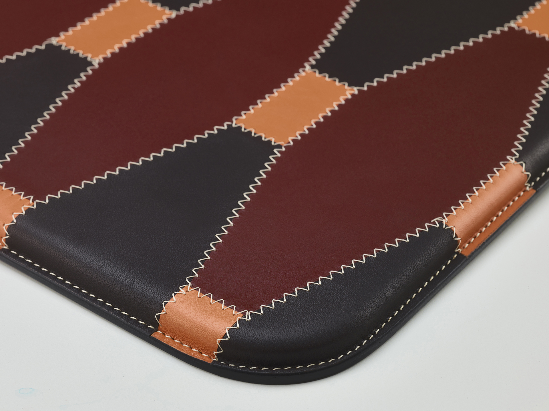 Detail of Tovaglietta Americana Patchwork, a patchwork American placemat that combines different colors of leather, from Promemoria's catalogue | Promemoria