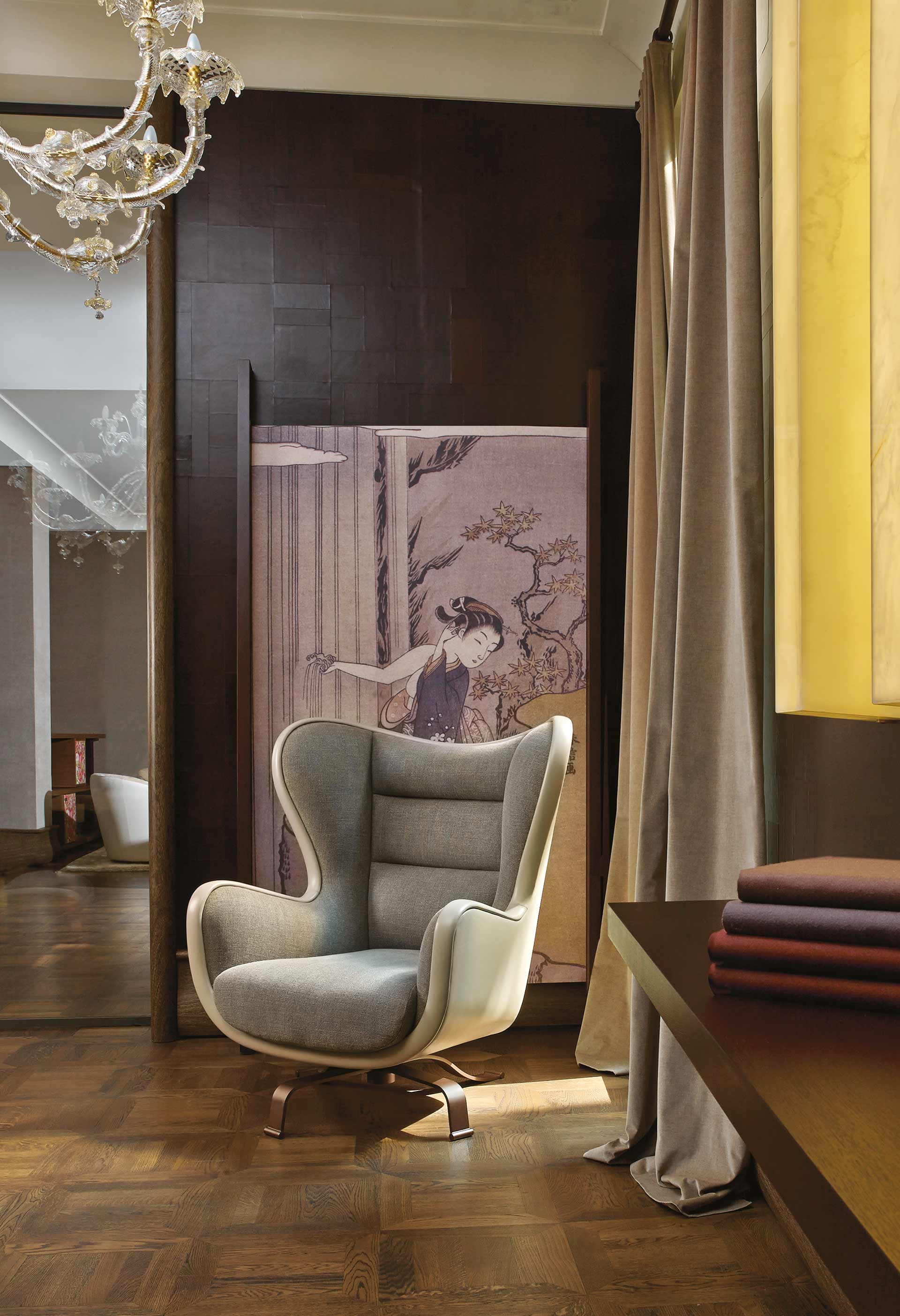 Butterfly is an armchair covered in fabric and leather with a revolving bronze base, from Promemoria's catalogue | Promemoria