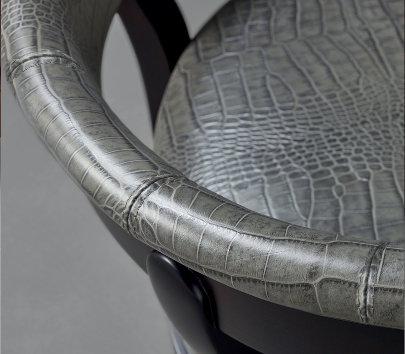 Feet detail of Chelsea, a wooden armchair covered in fabric or leather with bronze details, from Promemoria's catalogue | Promemoria