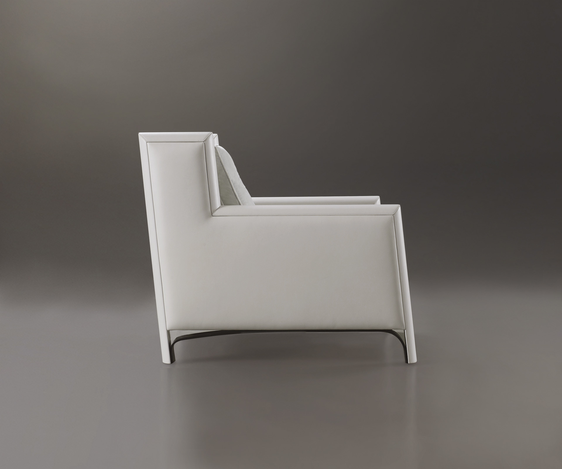 Ginevra is a wooden armchair covered in leather or fabric with bronze feet, from Promemoria's catalogue | Promemoria