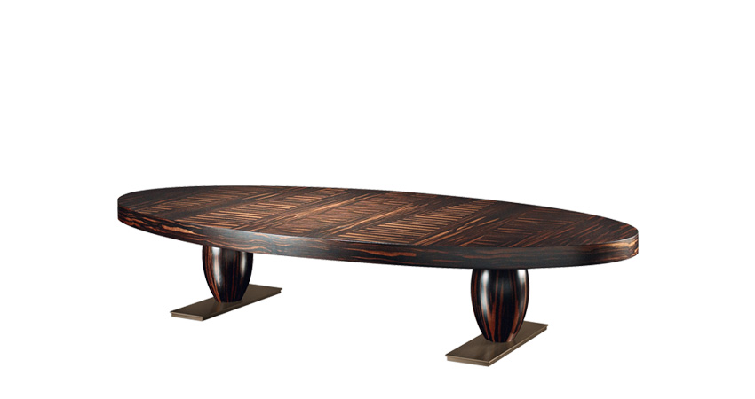 Bassano est une table basse ovale ou rectangulaire en bronze revêtue de cuir ou avec plateau marqueté. Ce meuble figure dans le catalogue Promemoria | Promemoria